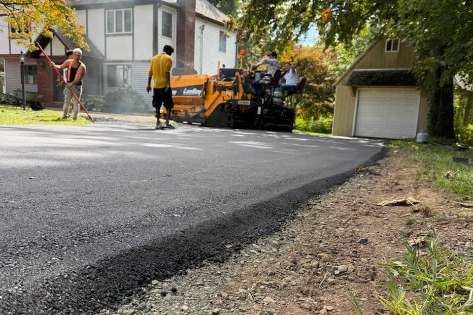 Top Notch Paving crew laying a fresh asphalt driveway with a paver